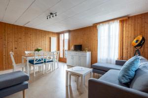 a living room with a couch and a table at Chalet Seehus Iseltwald in Iseltwald