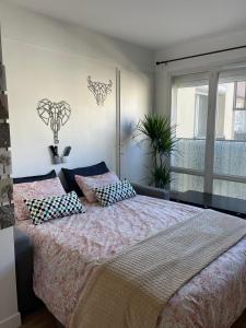 1 dormitorio con cama con almohadas y ventana en Résidence Carnot, en Alfortville