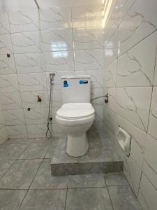 a bathroom with a white toilet in a room at Drew Apartment Tanga in Tanga