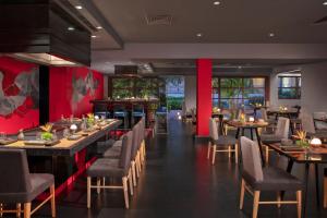 un restaurante con mesas, sillas y paredes rojas en Dreams Riviera Cancun Resort & Spa - All Inclusive, en Puerto Morelos