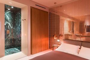 a bedroom with a bed and a glass wall at Taormina Infinity Suites in Taormina