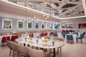 un comedor con mesas y sillas blancas en Dreams Riviera Cancun Resort & Spa - All Inclusive, en Puerto Morelos