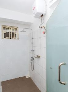 y baño con ducha y azulejos blancos. en Edville residence, en Kampala