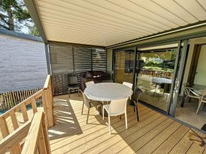 un patio con mesa y sillas en una terraza en Chalet Jullouville, 4 pièces, 6 personnes - FR-1-361-484, en Jullouville-les-Pins