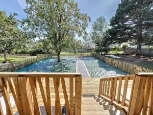 een zwembad met een boom op een houten terras bij Chalet Jullouville, 4 pièces, 6 personnes - FR-1-361-484 in Jullouville-les-Pins