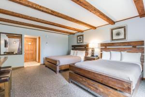 a bedroom with two beds and a table and a chair at Hotel Vienna in Windham