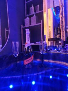 butelkę wina na stole z dwoma kieliszkami w obiekcie WOLA Wyjątkowe Studio z Jacuzzi, Sauną i Fotelem do Masażu oraz opcją z Prosecco - Exceptional Studio with Jacuzzi, Sauna, Massage Chair and optional Prosecco w Warszawie