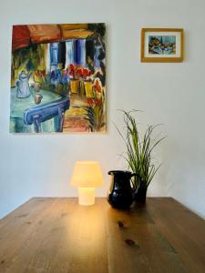 einen Tisch mit einer Lampe und ein Gemälde an der Wand in der Unterkunft Gästehaus Keins wie meins in Bad Hersfeld