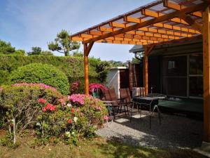 伊豆市にあるBouldering & SPA -Ariki Resort Shuzenji ANNEX- - Vacation STAY 07698vの木製のパーゴラ、椅子、花が咲くパティオ