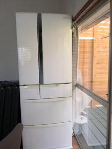 a white refrigerator in a room with a window at Bouldering & SPA -Ariki Resort Shuzenji ANNEX- - Vacation STAY 07698v in Izu