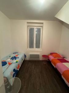 Zimmer mit 2 Betten, einem Tisch und einem Fenster in der Unterkunft Christelle in Romilly-sur-Seine