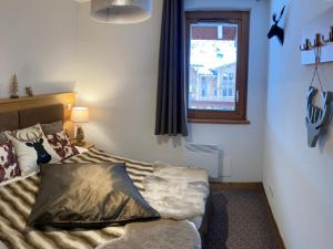 a bedroom with a bed and a window at Bel appartement avec piscine, sauna et parkings à Pralognan-la-Vanoise - FR-1-464-217 in Pralognan-la-Vanoise