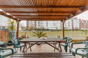 een houten picknicktafel en stoelen op een patio bij La terrazuca in Santander