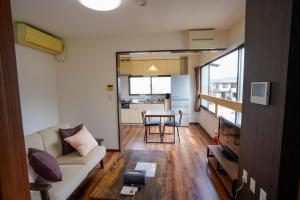 ein Wohnzimmer mit einem Sofa und einem Tisch in der Unterkunft Kotobuki-ke - Vacation STAY 15732 in Tsuru 