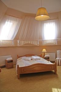 a bedroom with a bed and two windows at Ekran Hotel in Lviv