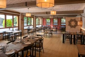 a dining room with tables and chairs and windows at Fonda Farré in Baro