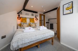 um quarto com uma cama grande e 2 almofadas brancas em RiizeRooms - self check in boutique hotel em Worcester