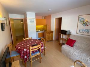 Cette petite chambre comprend une table et un canapé. dans l'établissement Appartement 37m² avec balcon, 500m centre village et pistes ski, parking privé - Autrans - FR-1-737-40, à Autrans