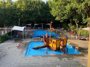 un groupe de personnes jouant dans un parc aquatique dans l'établissement Chalet Recreatiepark Duinhoeve 1, à Udenhout