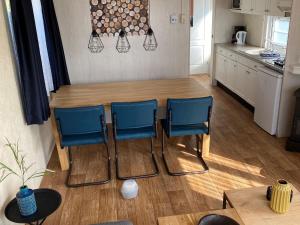 une cuisine avec une table et deux chaises bleues dans l'établissement Chalet Recreatiepark Duinhoeve 1, à Udenhout