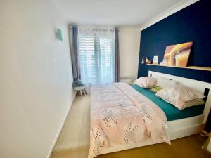 - une chambre dotée d'un lit avec un mur bleu dans l'établissement Splendid Apartment close to Paris, à Sèvres