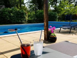 two drinks on a table next to a swimming pool at Guestroom Changé, 2 pièces, 4 personnes - FR-1-410-406 in Changé