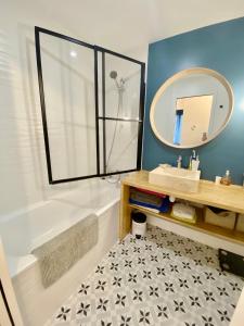 La salle de bains est pourvue d'une baignoire, d'un lavabo et d'un miroir. dans l'établissement Splendid Apartment close to Paris, à Sèvres