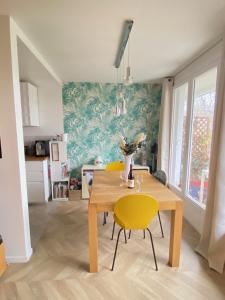 une salle à manger avec une table et des chaises jaunes dans l'établissement Splendid Apartment close to Paris, à Sèvres
