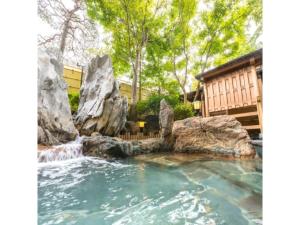 una piscina a cascata con rocce in un cortile di Sun Marine Kesennuma Hotel Kanyo - Vacation STAY 21044v a Kesennuma