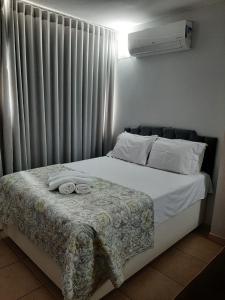 a bed with two towels on it in a bedroom at Loft centro de Goiânia 2108 in Goiânia