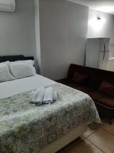 a bedroom with a bed with two towels on it at Loft centro de Goiânia 2108 in Goiânia