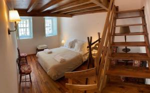 una camera con un grande letto con una scala di Quinta da Fontoura ad Alquerubim