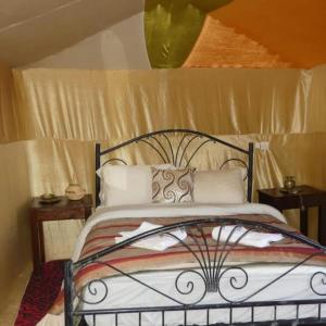 sypialnia z łóżkiem z metalową ramą w obiekcie Rihanna Desert Camp w mieście Merzouga