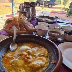 stół z miską jedzenia z łyżką w obiekcie Rihanna Desert Camp w mieście Merzouga