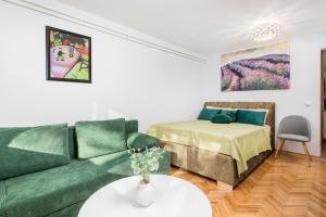 een woonkamer met een bank en een bed bij Studio Roko in Rijeka
