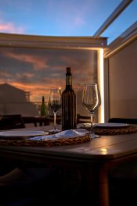 a bottle of wine and two wine glasses on a table at Hotel Boutique Calas de Alicante in Alicante