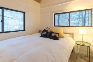 um quarto com uma cama branca e 2 janelas em Konayuki Cabin Hakuba - Vacation STAY 22044v em Hakuba