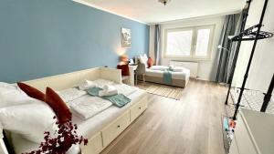 a bedroom with blue walls and a bed and a couch at Privatunterkunft in Uetersen bei Hamburg in Uetersen