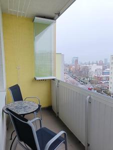 a balcony with a table and chairs and a window at Riazanska Residence 3 room Free Wi-Fi in Bratislava