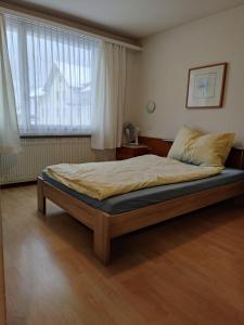 Bett in einem Zimmer mit einem großen Fenster in der Unterkunft Hotel Rebstock Meiringen in Meiringen