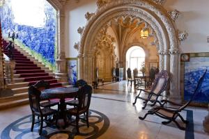 a room with chairs and tables in a building at Palace Hotel do Bussaco in Luso