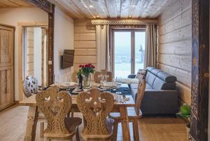 - une salle à manger avec une table, des chaises et un canapé dans l'établissement Galicowa Chata, à Murzasichle