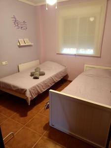two beds in a small room with a window at Chalet Adosado en Rincón in Rincón de la Victoria