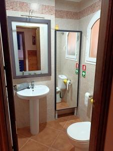 een badkamer met een wastafel, een toilet en een spiegel bij Chalet Adosado en Rincón in Rincón de la Victoria