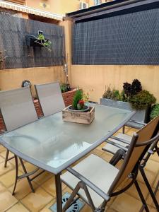 een glazen tafel en stoelen op een patio bij Chalet Adosado en Rincón in Rincón de la Victoria