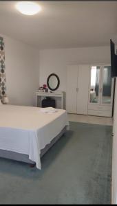 ブカレストにあるDC Ghencea 158 Self Check-inの白いベッドルーム(ベッド1台、鏡付)