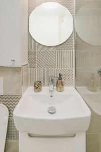 a bathroom with a white sink and a mirror at Cochet Studio in Focşani