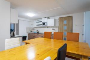 - une cuisine avec une table en bois et des chaises orange dans l'établissement Turistická chata Nesnídalka, 