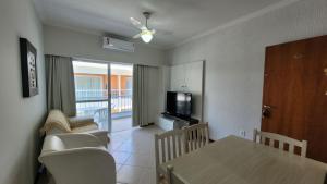 a living room with a dining table and a television at B720 - Apartamento 2 quartos em cond. com piscina in Bombas