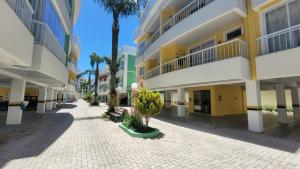 an empty street in front of a building with palm trees at B720 - Apartamento 2 quartos em cond. com piscina in Bombas